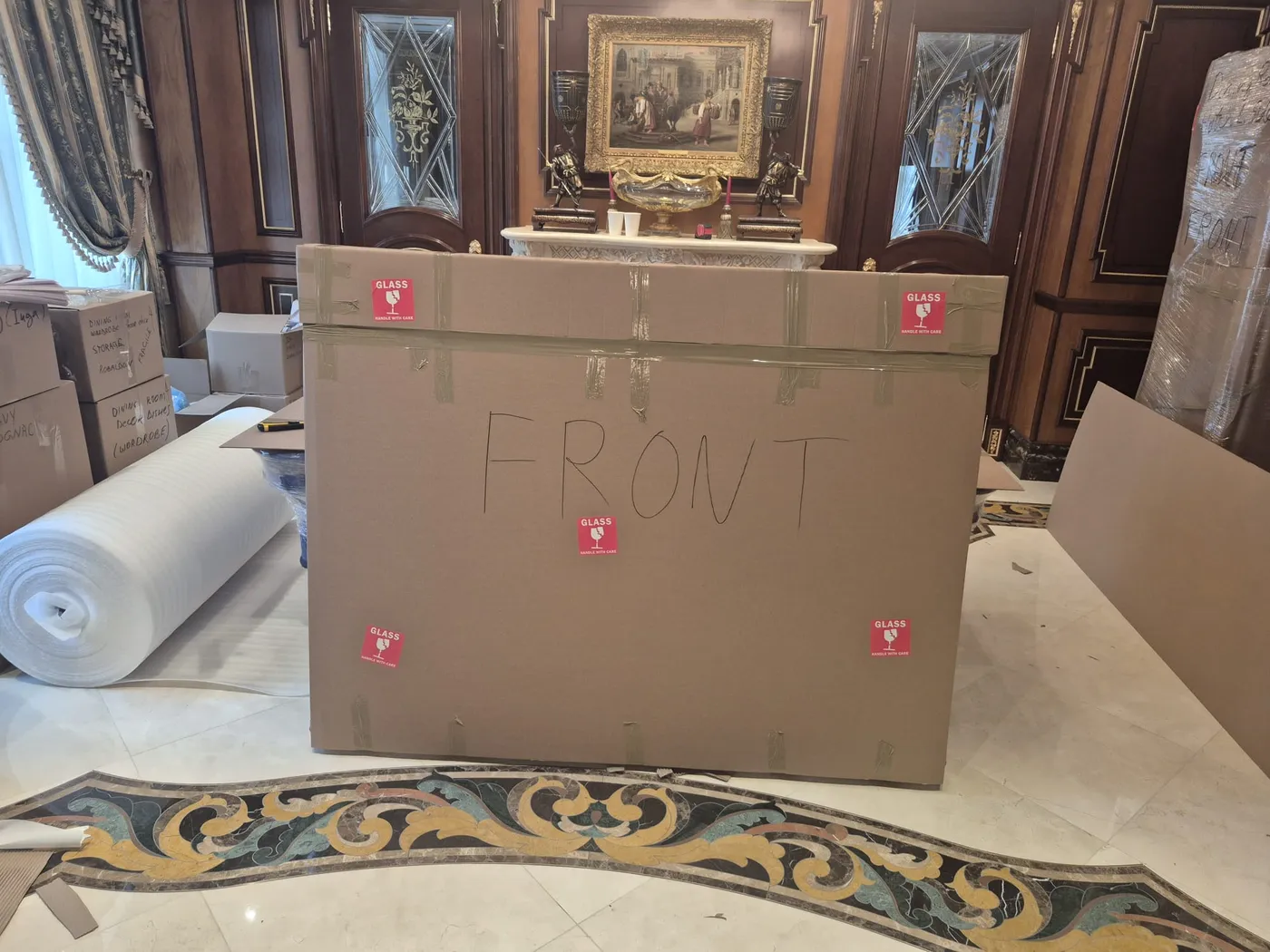 A large custom cardboard crate marked 'front' for fragile item transport