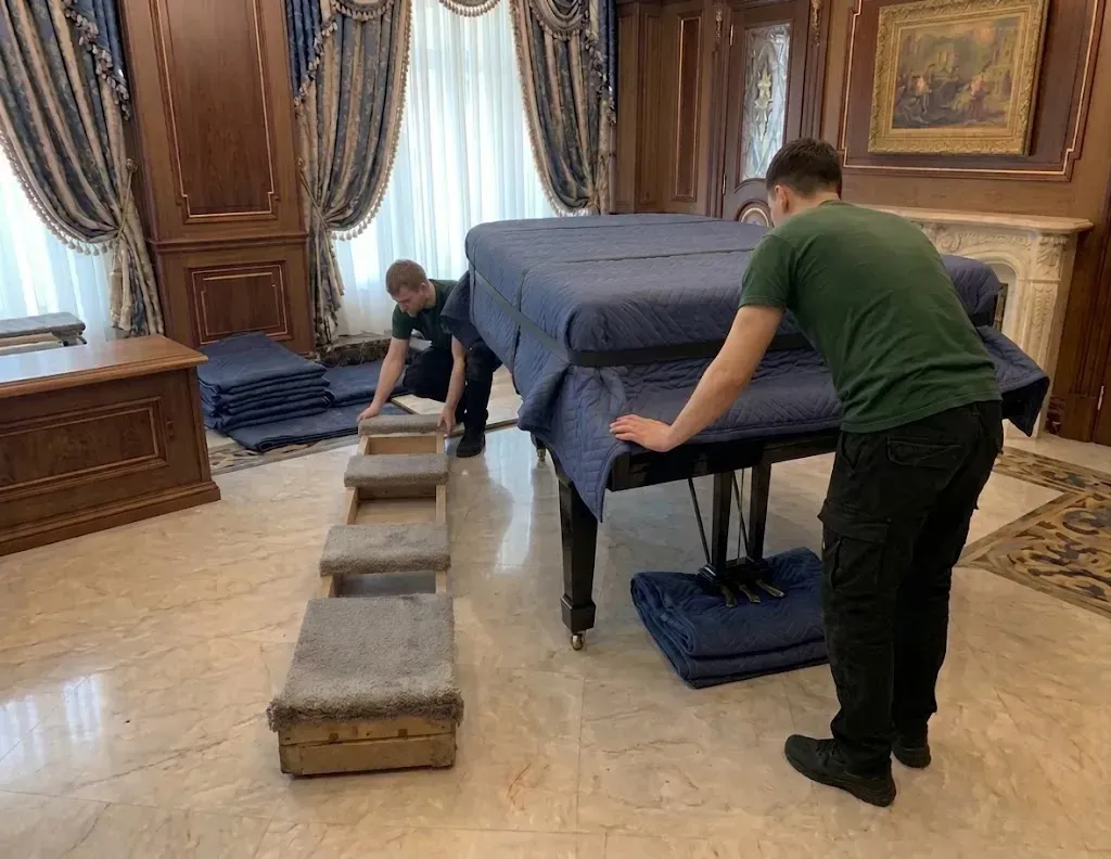 Padded skid board positioned on the floor for piano protection